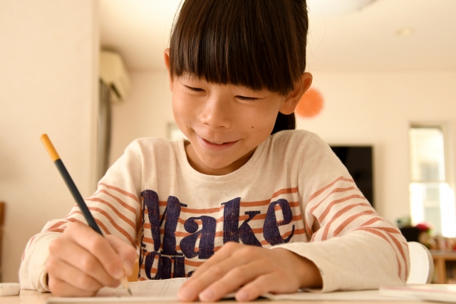 笑顔で算数の問題を解く小学生