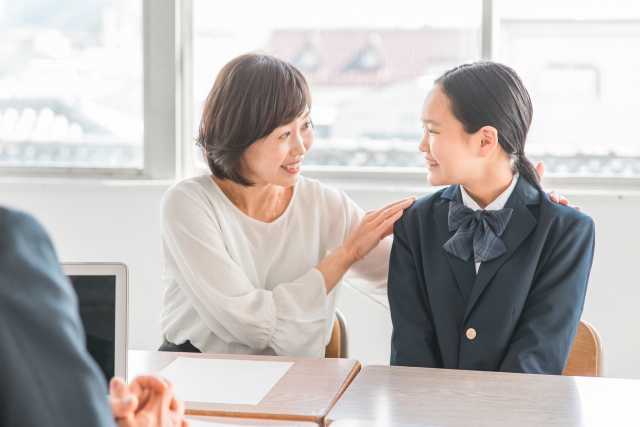 学校の懇談を笑顔で受ける母親と娘