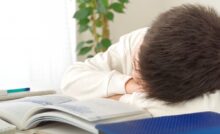 勉強しながら居眠りする小学生